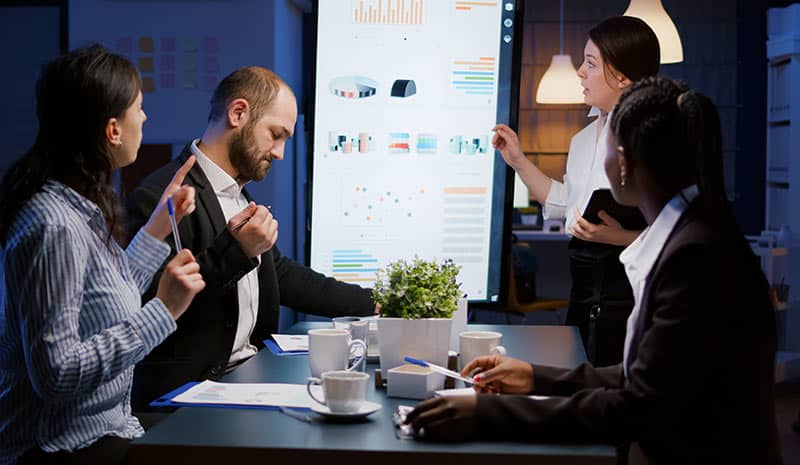 Un manager et son équipe pendant une session de travail en soirée.